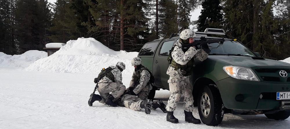 Neljä sotilaspoliisia harjoittelee vaarallisen henkilön kiinniottoa.