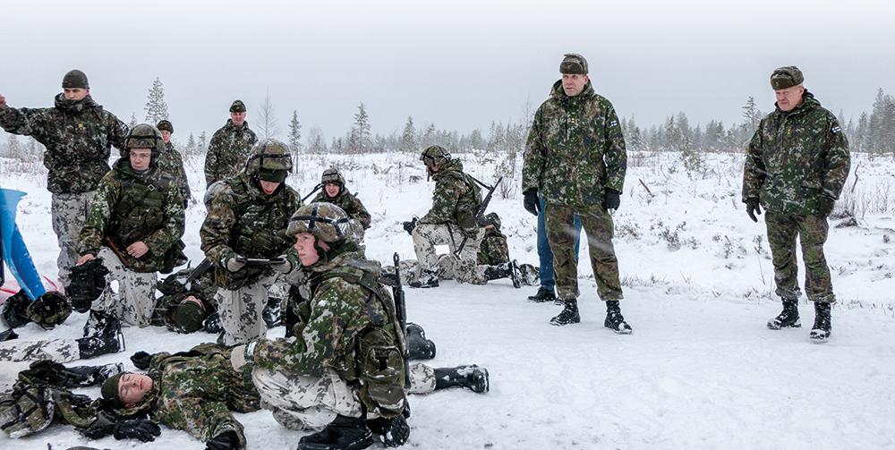 Puolustusvoimien koulutuspäällikkö seuraa kaatuneiden huollon koulutusta lumisateessa.