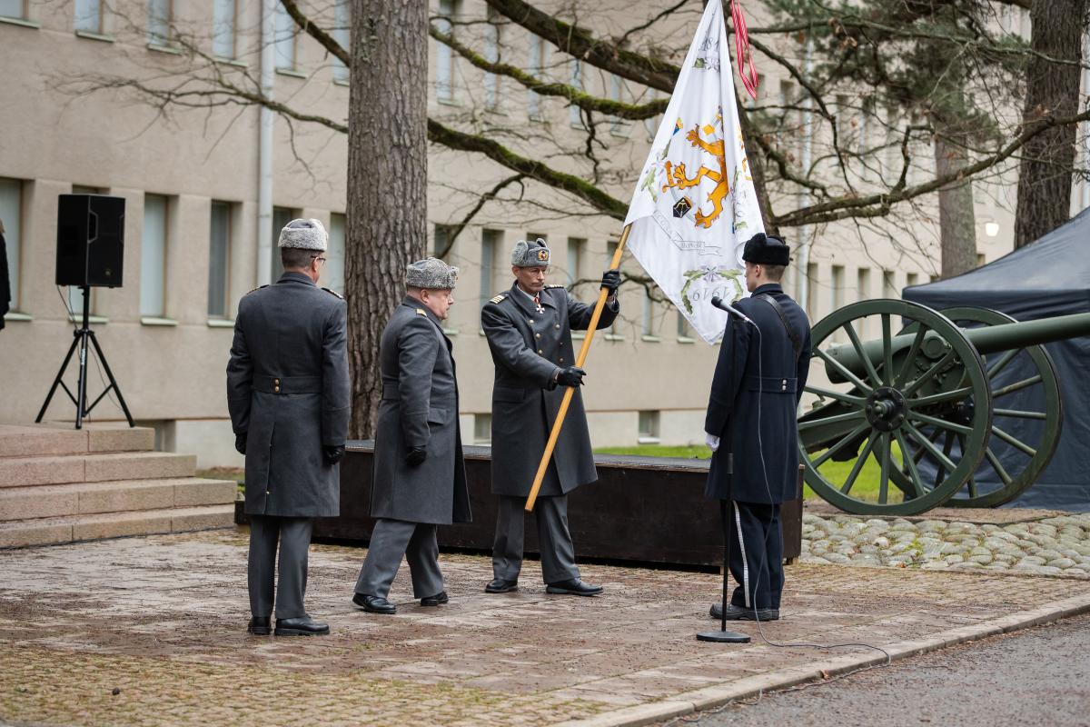 Kuvassa sotilas ojentaa Kadettikoulun valkean lipun takaisin lippuvartiolle.