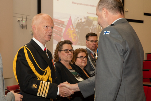 Generalmajor Jari Kallio skakar hand med biträdande professorn Mikko Karjalainen.