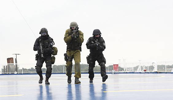 Three tactically equipped soldiers on the ship's deck